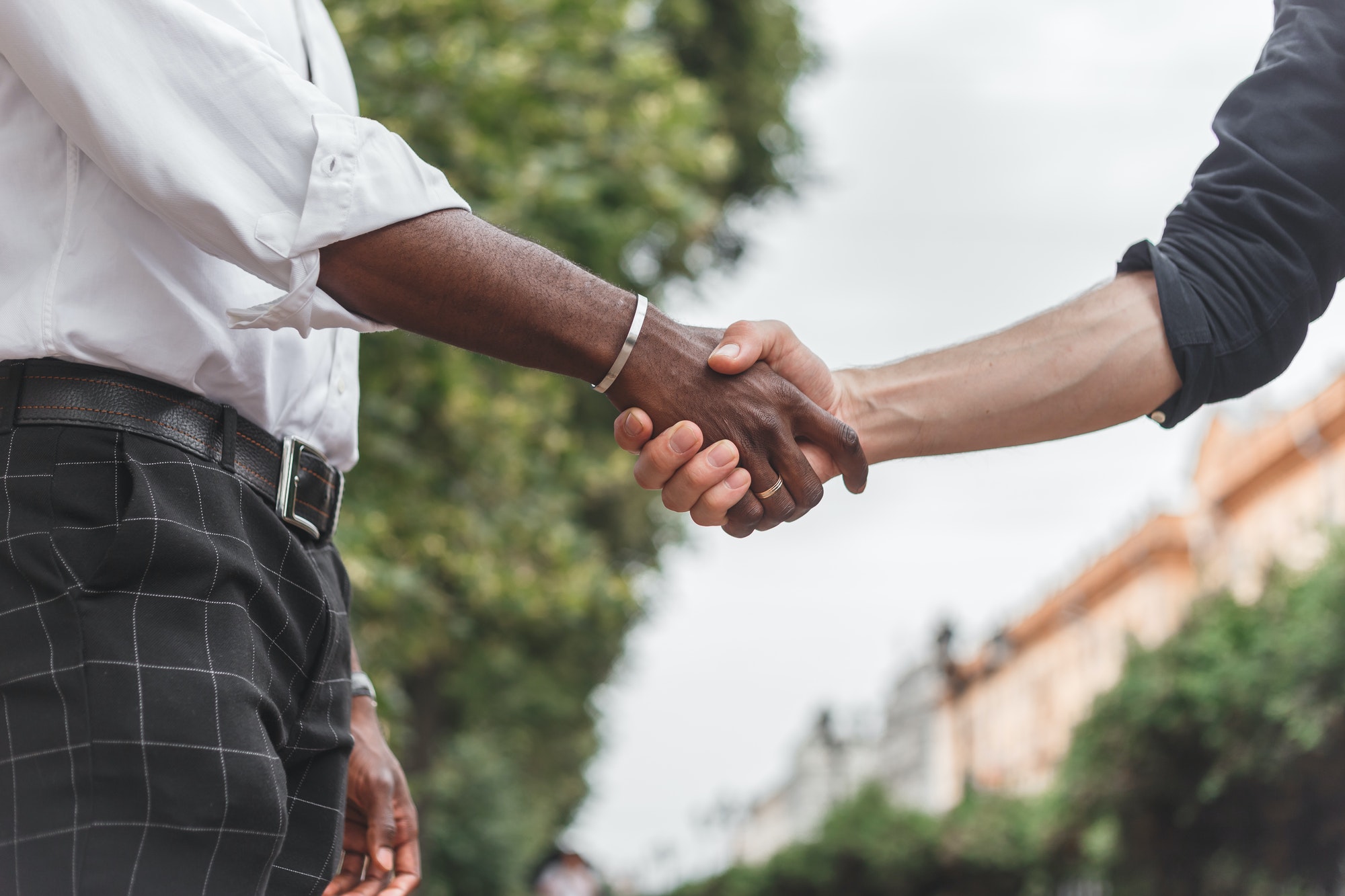 Handshake between african and a caucasian man outdoors