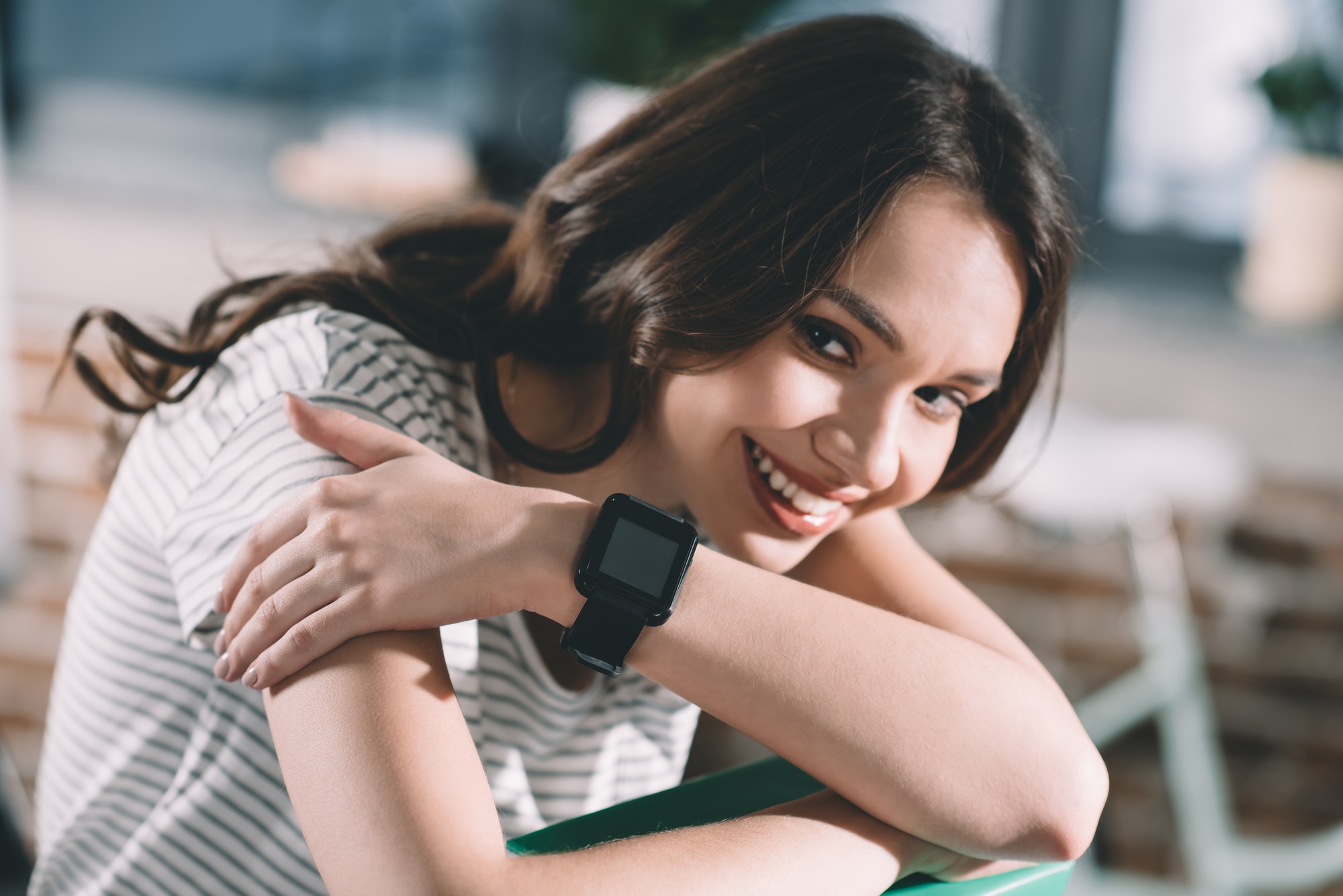 portrait of smiling woman with smartwatch on wrist